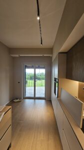 Portafinestra minimale che porta luce nella cucina di un villino a Lariano, nei Castelli Romani